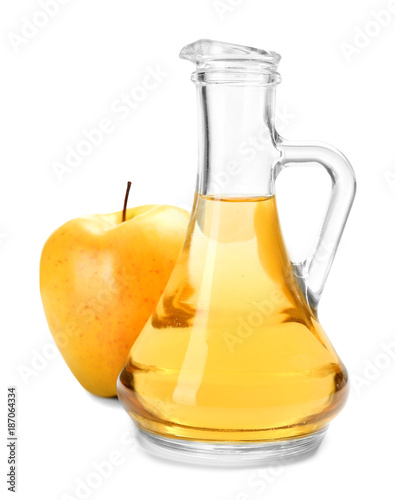 Glass jug with apple vinegar and fresh fruit on white background