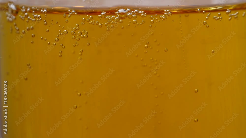 Glass full of beer slow moving bubbles. Yellow drink background Glass full of beer slow moving bubbles. Yellow drink background