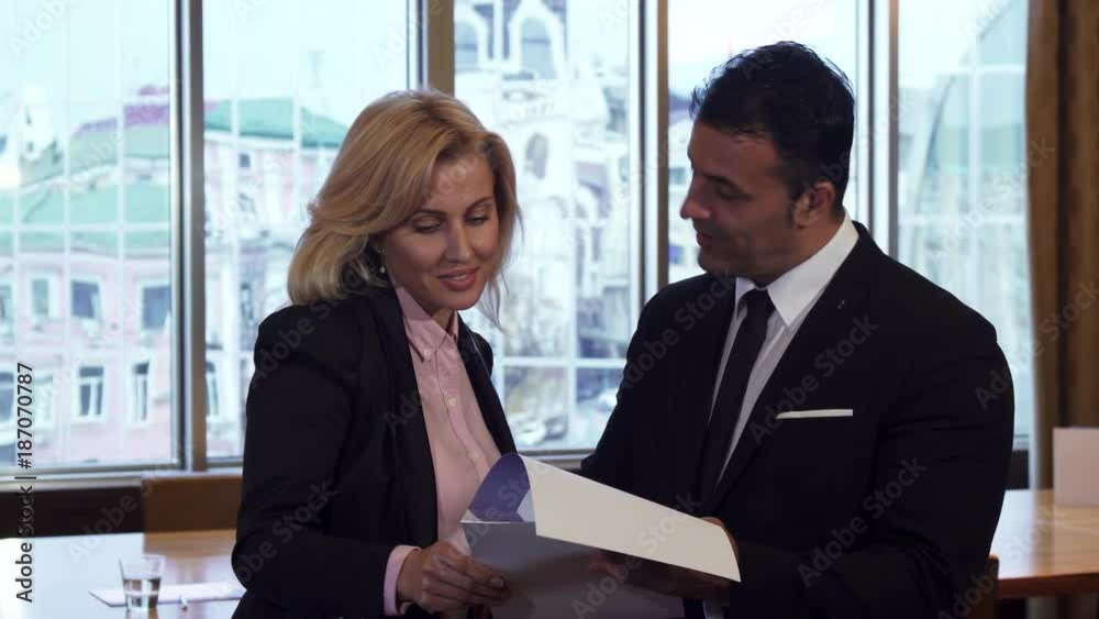A business man and a woman are discussing a working contract A business man and a woman are discussing a working contract