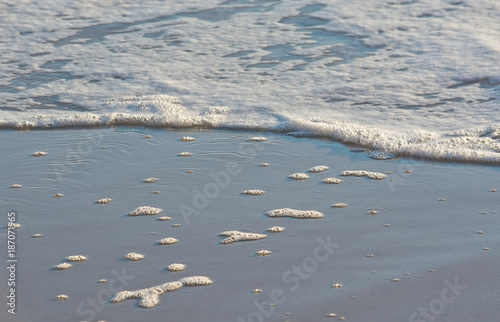 Sandy beach detail foam abstract shapes