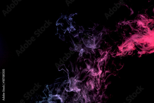 Dense multicolored smoke of purple and pink on a black isolated background. Background of smoke vape