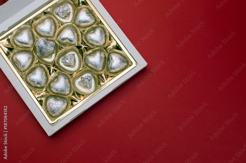 Fototapeta premium Beautiful love concept for Valentines day. Opened sweet box with chocolate heart shaped sweets inside.
