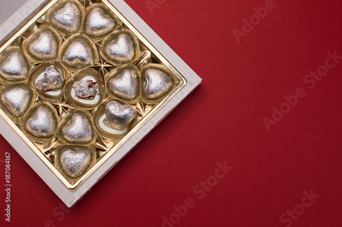 Beautiful love concept for Valentines day. Opened sweet box with chocolate heart shaped sweets inside.