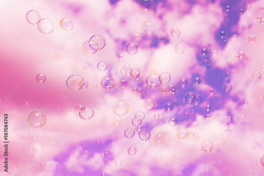 Abstract background : Beautiful soap bubbles reflecting various color floating on sky and white cloud background.