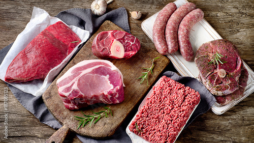 Obraz na płótnie Different types of raw meat on dark wooden background.