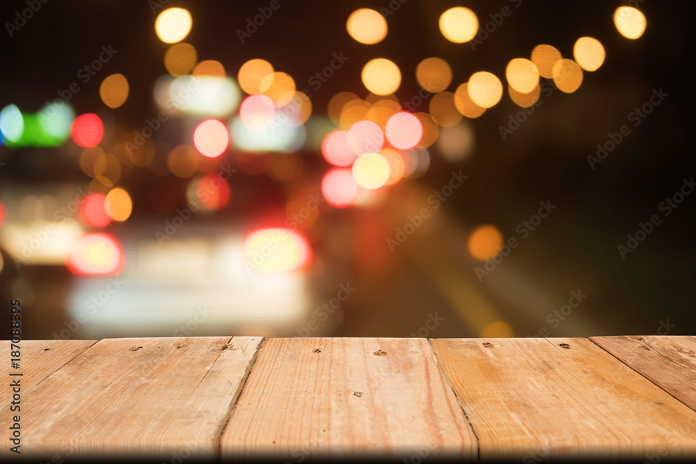 Blank wooden table on front abstract background of traffic jam, bokeh light