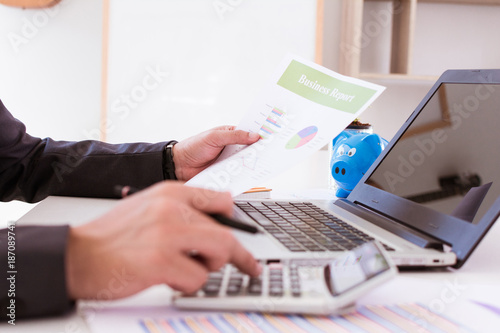 Businessman working with calculator, Business document and laptop computer notebook. Businessman is reading the report and analyzing graph report.