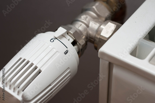 Heating controler on a white radiator close up macro shot.
