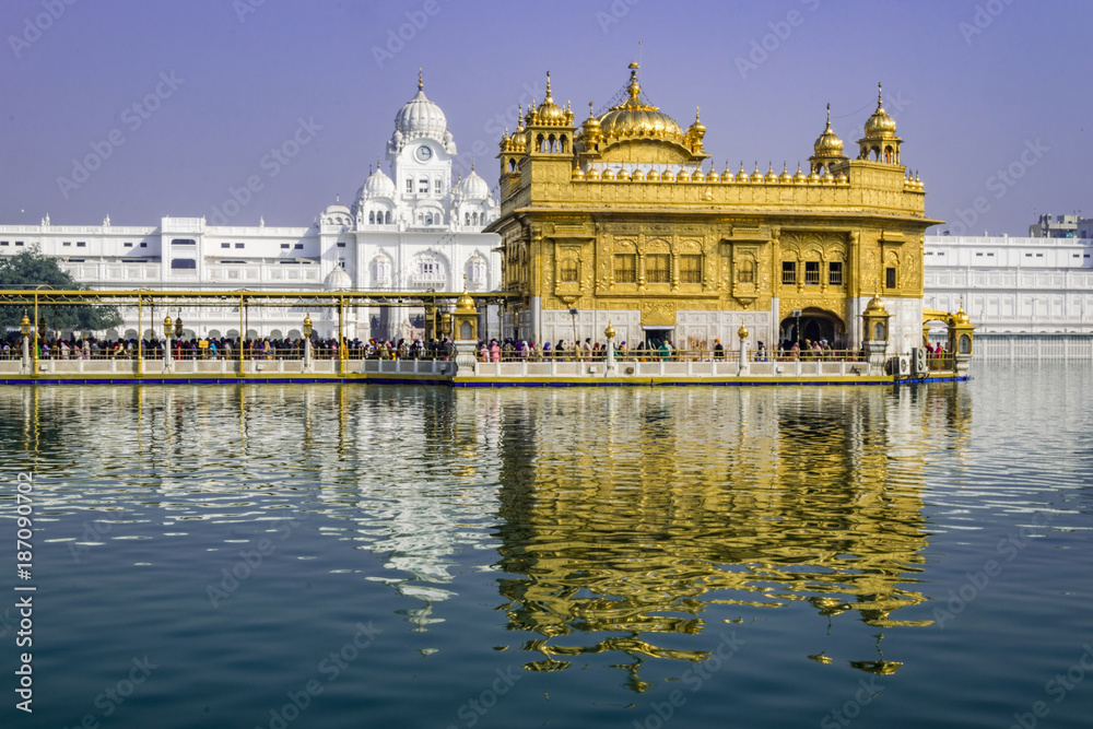Golden Temple, Sikh Gudwara in Amritsar, India. .Reflections on sacred pond of Harmandir Sahib, holiest shrine of the Sikh religion. Famous Indian landmark on sunny day.