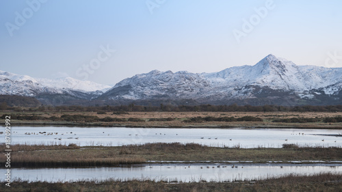 Beautiful Winter sunrise landscape image of Mount Snowdon and other peaks in Snowdonia National Park