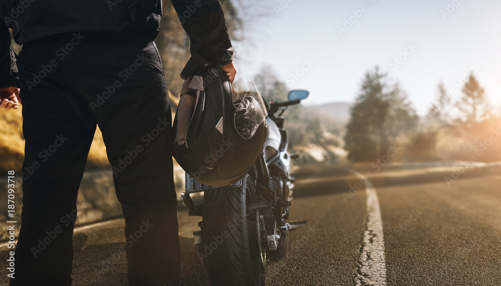 Fototapeta premium Motocyklista z motocyklem na drodze