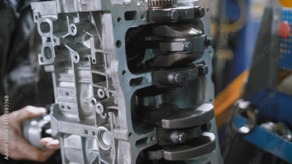 mechanic is repairing car engine in a workshop, tightening bolts, using wrench, close-up of a crankshaft mechanic is repairing car engine in a workshop, tightening bolts, using wrench, close-up of a crankshaft