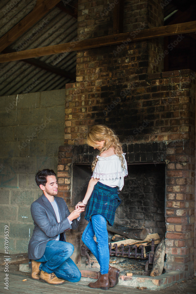 The young romantic handsome man doing proposal his young beautiful woman near the brick oven The young romantic handsome man doing proposal his young beautiful woman near the brick oven