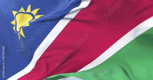 Namibia flag waving at wind in slow in blue sky, loop photo