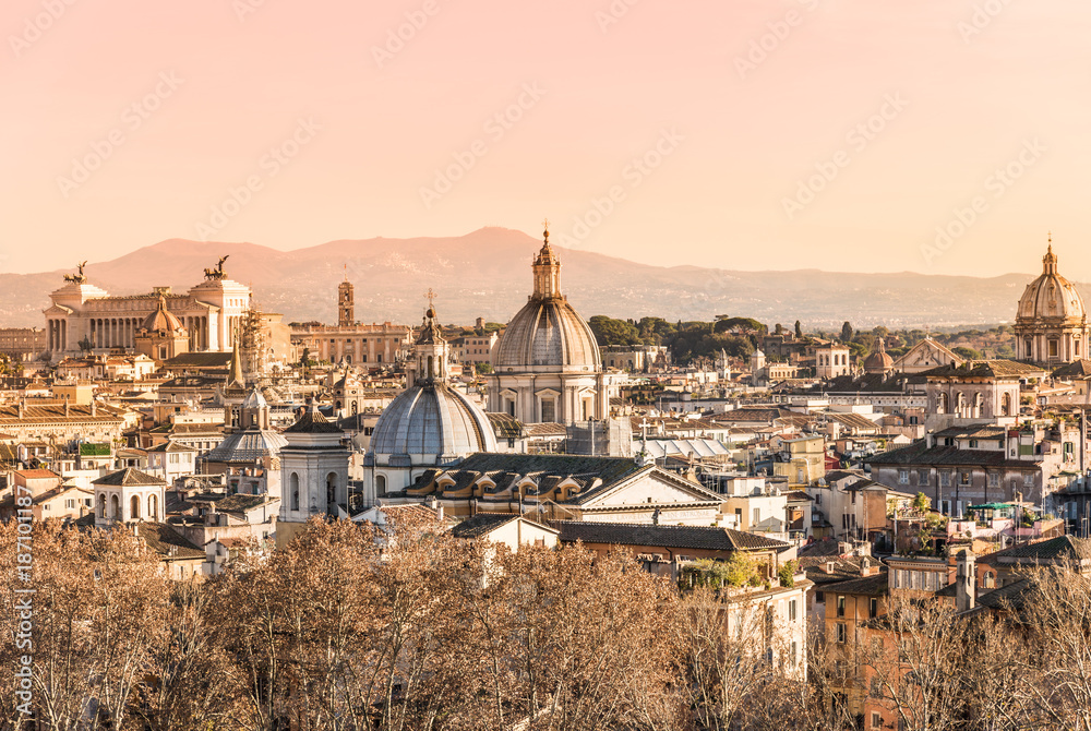 Rooftops view of Rome historical architecture and city skyline at sunset, Italy.