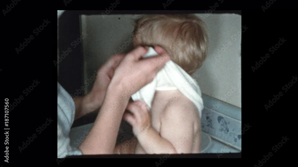 1953 Mom changes baby and kisses his belly
