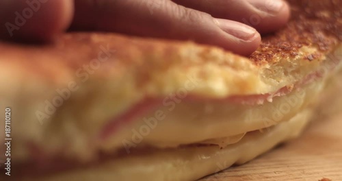 closeup of handmade delicious sandwich with ham and cheese. cutting it and press to show cheese texture. breackfast sandwich
