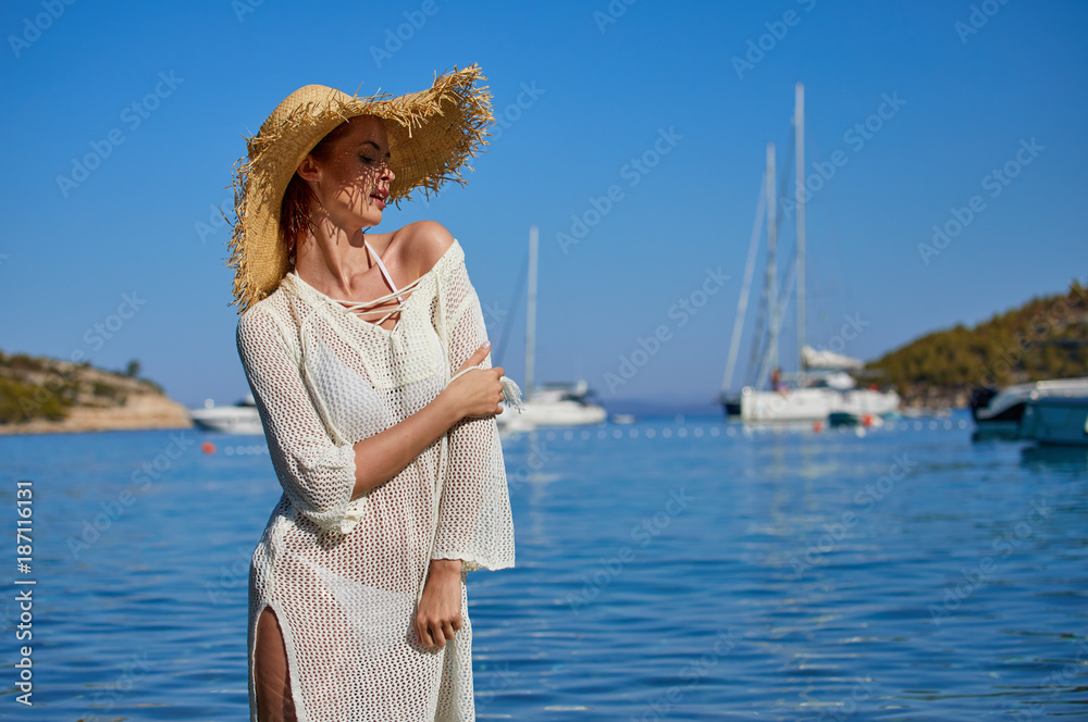 Sexy beautiful woman in white bikini on Mediterranean sea coast