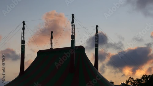 dark big top in the background with moving clouds at sunset