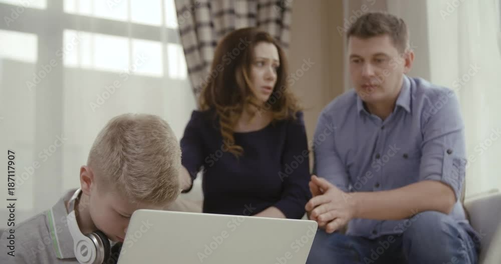 Parents are very unhappy that the son spends much time at the computer. Сoncept of Internet addiction. Dolly shot. 4K