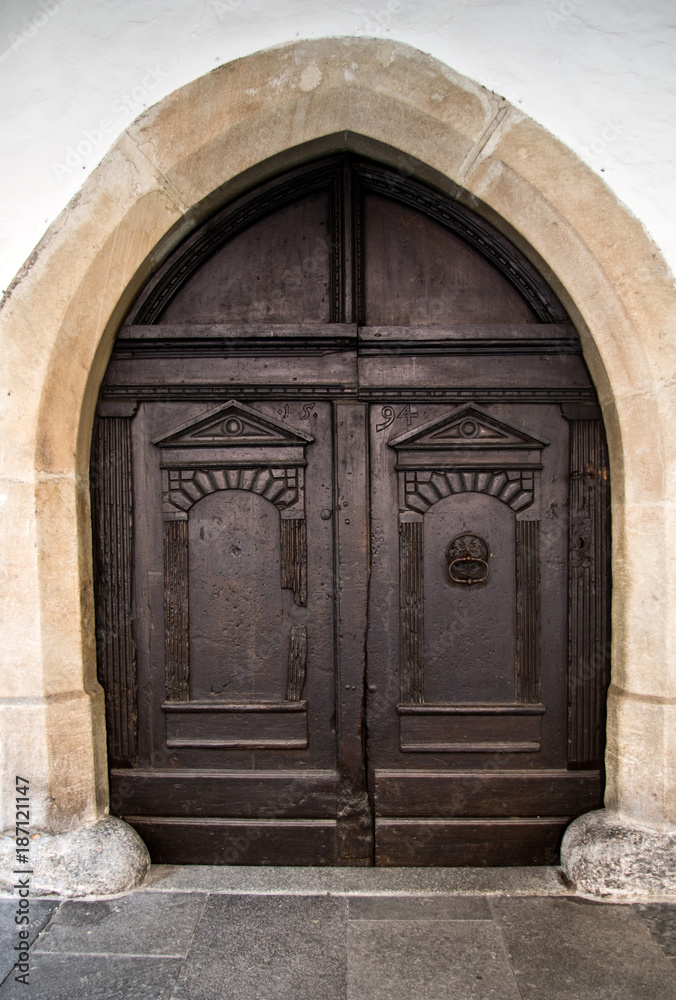 ancient wooden door with knocker and closing mechanism