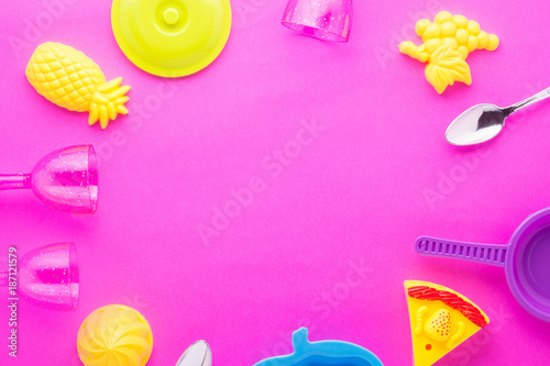 Miniature toy kitchenware on pink background.