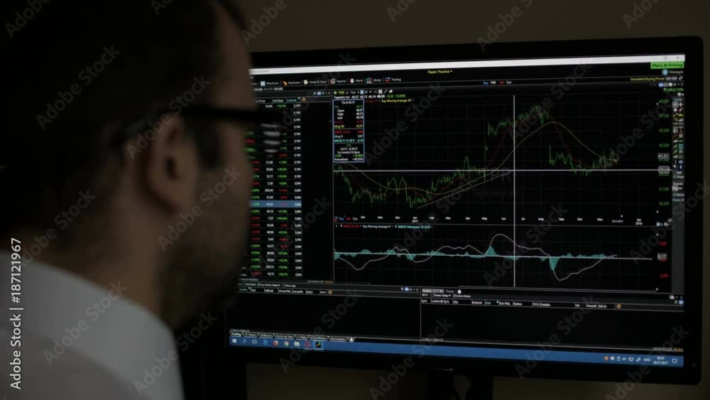 Businessman sitting and using computer showing trading graph stock exchange trading graph screen background, Business financial and forex concept. Kaliningrad - November 2017 Russian.
