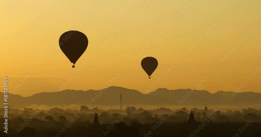 Scenic sunrise with many hot air balloons above Bagan in Myanmar. Bagan is an ancient city with thousands of historic buddhist temples and stupas. Scenic sunrise with many hot air balloons above Bagan in Myanmar. Bagan is an ancient city with thousands of historic buddhist temples and stupas.