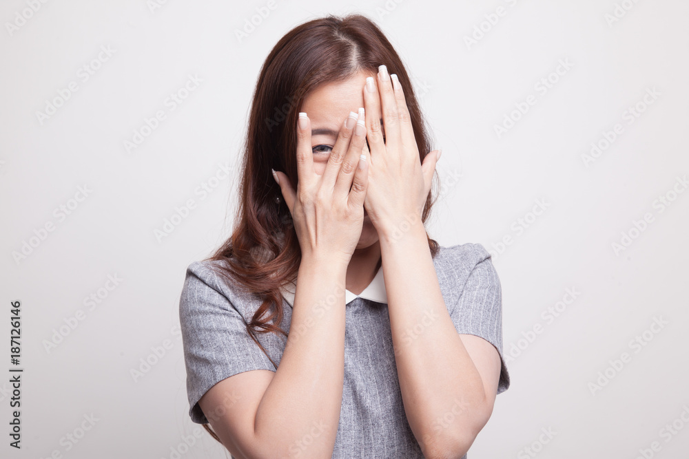 Beautiful young Asian woman peeking through fingers. Beautiful young Asian woman peeking through fingers.