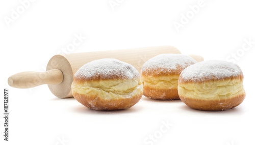 Sufganiyah three traditional doughnut with a rolling pin isolated on white background fresh baked with powered sugar and without hole. photo