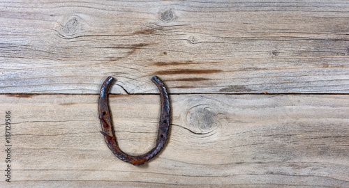 Lucky rusty horseshoe for St Patick holiday on wooden background