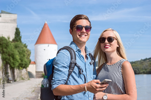 Happy smiling tourists with smartphone in Passau