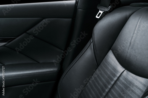 Modern luxury car black perforated leather interior. Part of leather car seat details. Modern car interior details © Aleksei