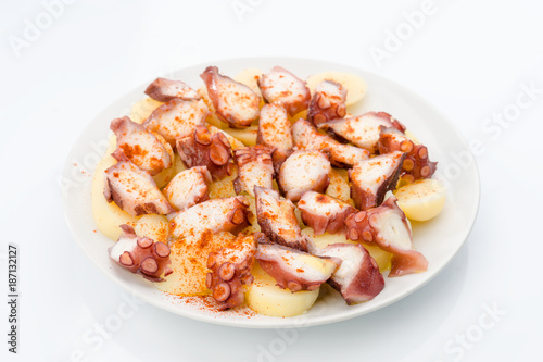 Marinated octopus sliced on potatoes isolated on white