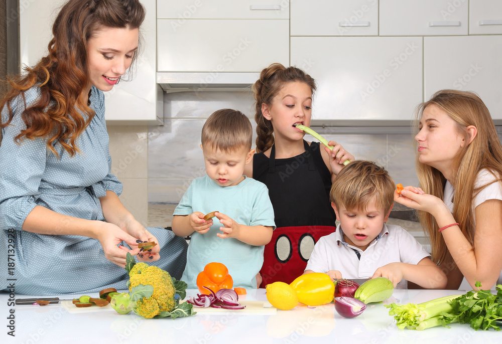mother with children preparing vegetables in the kitchen mother with children preparing vegetables in the kitchen