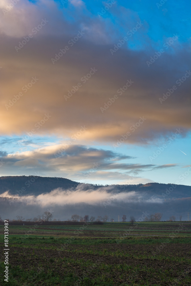 Landschaftsidyll mit farbigem Himmel und Nebel