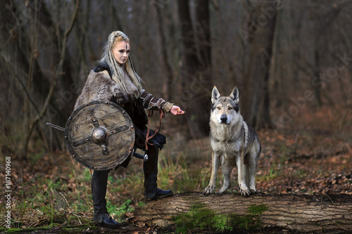 Schilderij op canvas Beautiful viking warrior woman in traditional warrior clothes, with ax and shiel