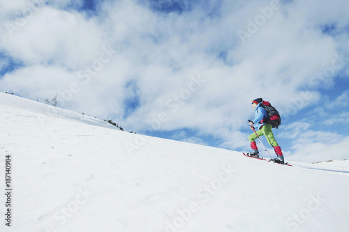 Hiker in winter mountains. Man with backpack trekking in mountains. Winter hiking.