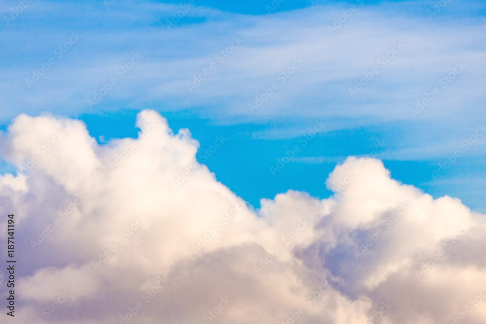 Fluffy clouds against a bright blue sky (background)