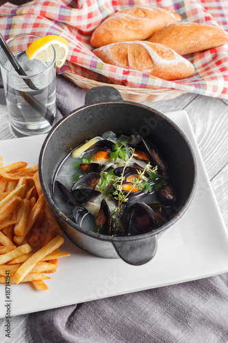 Mussels in a pot served with fried potato. Top view. Restaurant menu conception