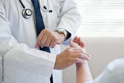 Male doctor taking patient's pulse
