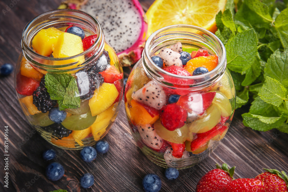 Jars with delicious fruit salad on wooden table Jars with delicious fruit salad on wooden table