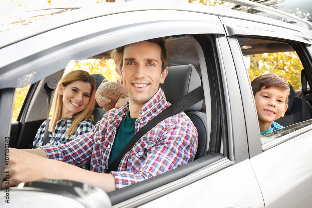 Young couple with their little son in car