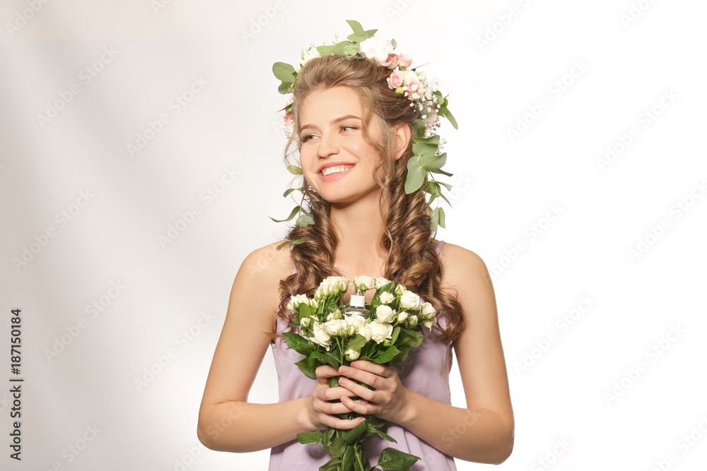 Beautiful young woman with bouquet of flowers and floral perfume on white background Beautiful young woman with bouquet of flowers and floral perfume on white background