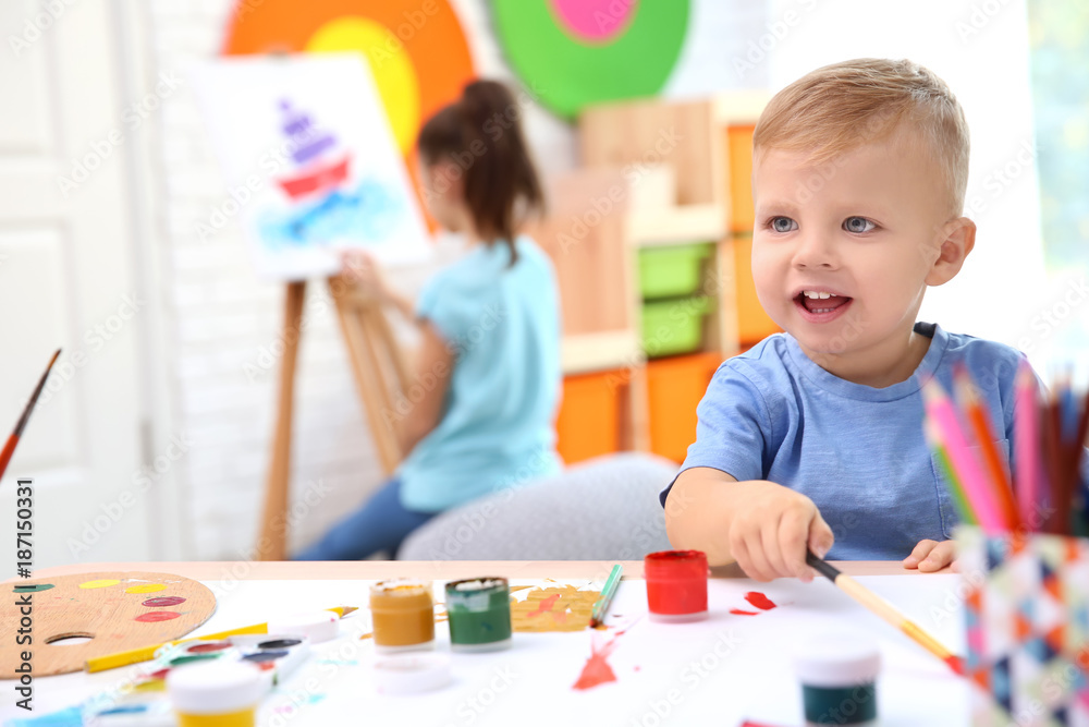 Obraz premium Little boy and blurred girl painting indoors
