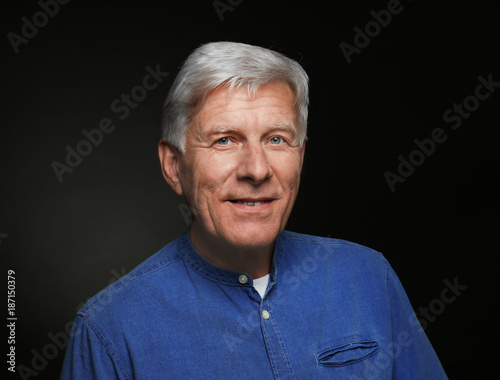 Portrait of handsome mature man on dark background © Africa Studio