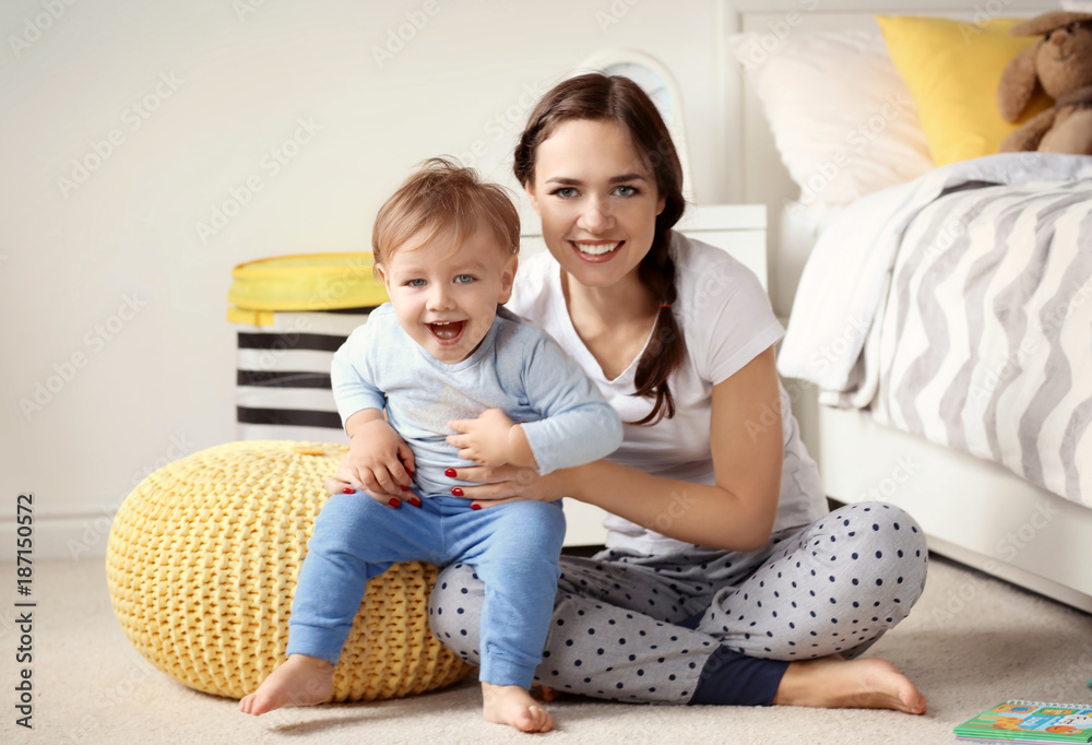 Fototapeta premium Beautiful young woman with her baby at home