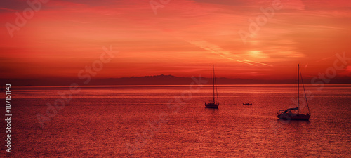 Beautiful colorful sunset at the sea with two sailing boats . Beauty world natural outdoors travel background