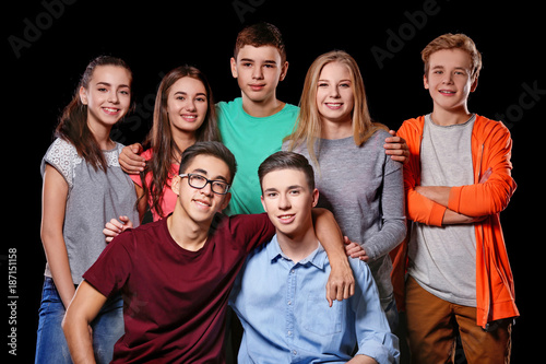 Group of cool teenagers on dark background