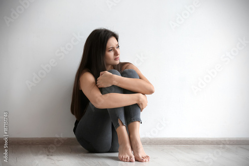 Depressed young woman sitti...